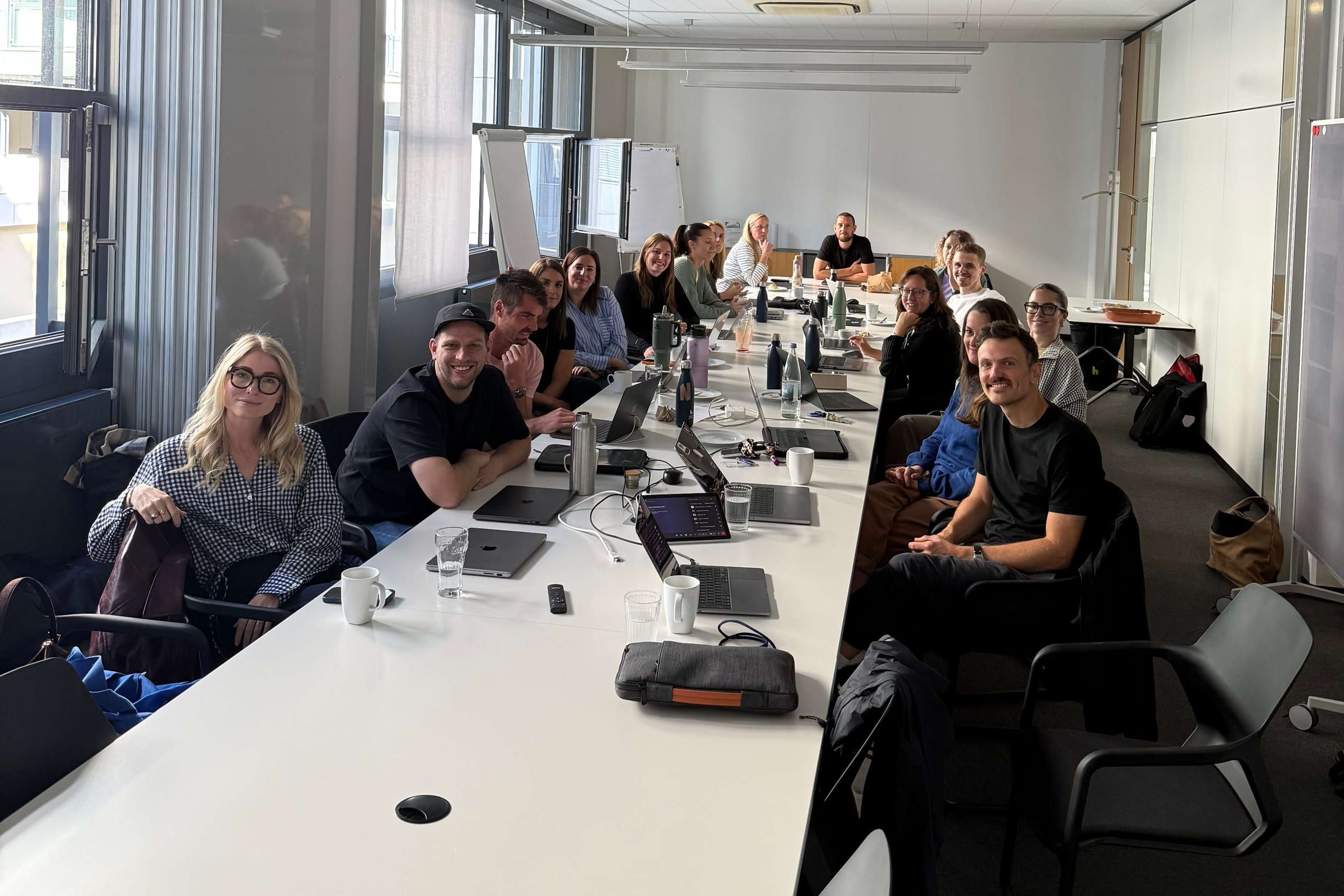 Das Marketing-Team der Haufe Akademie am langen Konferenztisch während des KI-Workshops, alle schauen in die Kamera
